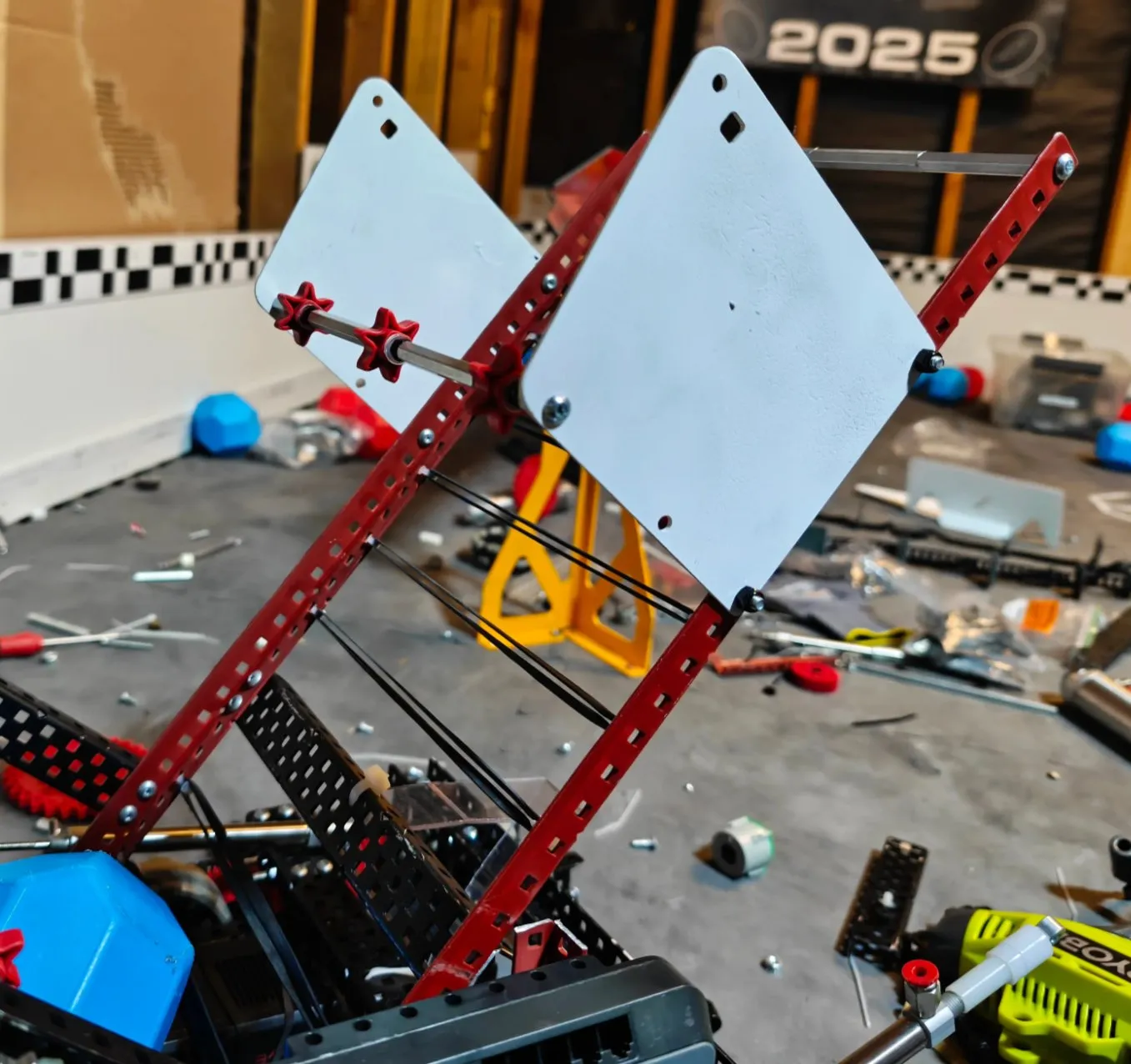 The intake and lift structure of the Push Back robot in the first phase of assembly, a large white polycarbonate plate on red rails.